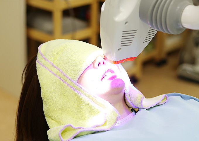 審美歯科治療のホワイトニングをする女性